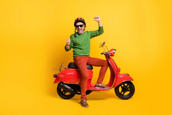 Φωτογραφία του ενθουσιασμένος άνθρωπος με ποδήλατο αυξήσει τις γροθιές φορούν κράνος specs πράσινο πουλόβερ παντελόνι παπούτσια απομονωμένο κίτρινο χρώμα φόντο — Φωτογραφία Αρχείου