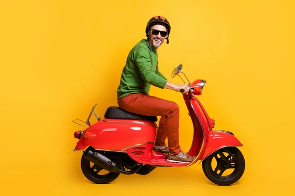 Photo of man drive kerékpár kopás sisak napszemüveg zöld pulóver nadrág lábbeli elszigetelt sárga színű háttér — Stock Fotó