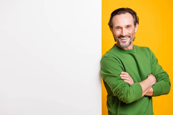 Foto do homem cruzado mãos parede branca espaço vazio dente sorriso desgaste verde pulôver isolado cor amarela fundo — Fotografia de Stock