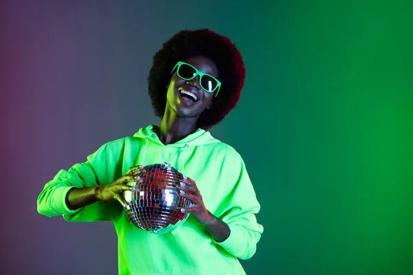 Zdjęcie beztroski disco 80s styl lady trzymać świecące kulki nosić sunglass bluza odizolowany gradient zielony neon tło — Zdjęcie stockowe