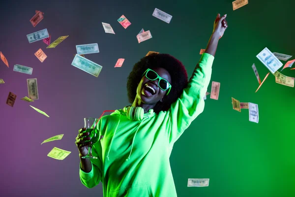 Retrato de louco animado escuro pele senhora levantar mão apontar dedo cair dinheiro isolado no verde colorido fundo — Fotografia de Stock