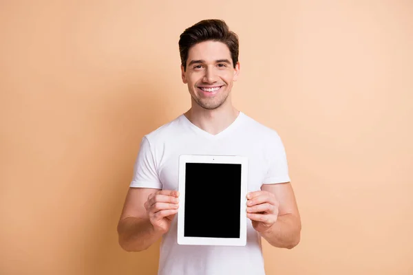 Foto de jovens satisfeitos sorrir mãos segurando tablet mostrar exibição isolada no fundo cor bege — Fotografia de Stock