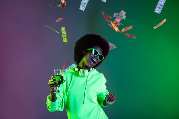 Photo of 80s style lady hold glass straw banknoty deszcz nosić sunglass bluza odizolowany gradient zielony neon tło — Zdjęcie stockowe