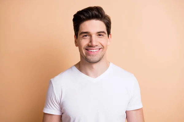 Zdjęcie szczęśliwego charyzmatycznego młodego człowieka promieniejącego uśmiechem dobry nastrój odizolowany na pastelowym beżowym tle koloru — Zdjęcie stockowe