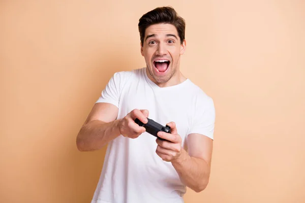 Portret van positieve zorgeloze verbaasd persoon open mond spelen spellen geïsoleerd op beige kleur achtergrond — Stockfoto