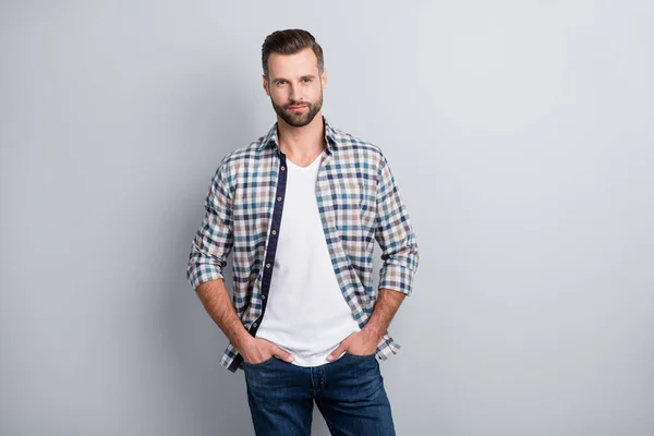 Retrato fotográfico de un hombre serio y confiado que mantiene las manos en bolsillos con camisa a cuadros aislada sobre fondo de color gris — Foto de Stock