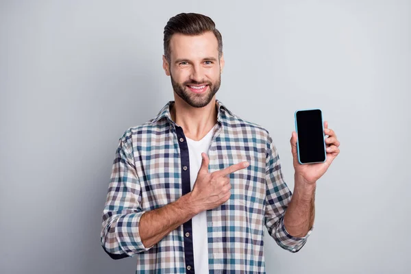 Retrato de cara barbudo alegre atraente segurando na mão demonstrando anúncio gadget isolado sobre fundo de cor pastel cinza — Fotografia de Stock