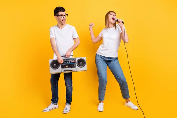 Foto av funky personer klädd vit t-shirt glasögon som visar lyssna bom box sjunga mikrofon isolerad gul färg bakgrund — Stockfoto