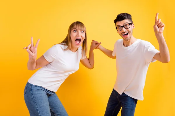Фото сладких милых двух человек одетых в белые очки футболки танцы показывая V-знак указывая изолированный желтый цвет фона — стоковое фото