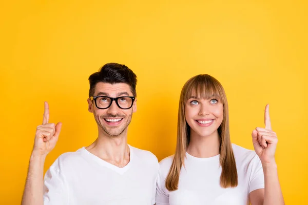Foto di bella adorabile giovane coppia indossare bianco t-shirt occhiali cercando indicando lo spazio vuoto isolato colore giallo sfondo — Foto Stock