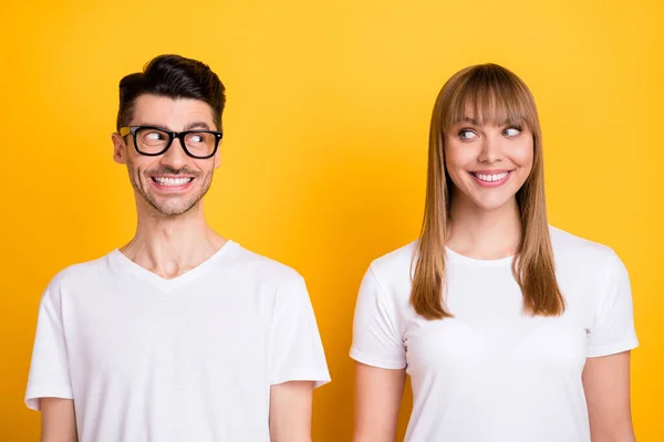 Foto de casal jovem doce engraçado desgaste branco t-shirt óculos olhando uns para os outros isolado cor amarela fundo — Fotografia de Stock