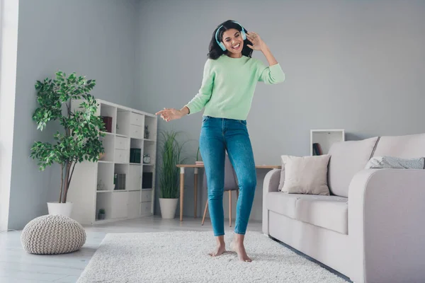 Foto de larga duración de la piel oscura joven mujer funky danza sonrisa usar auriculares amante de la música en el interior de la casa — Foto de Stock