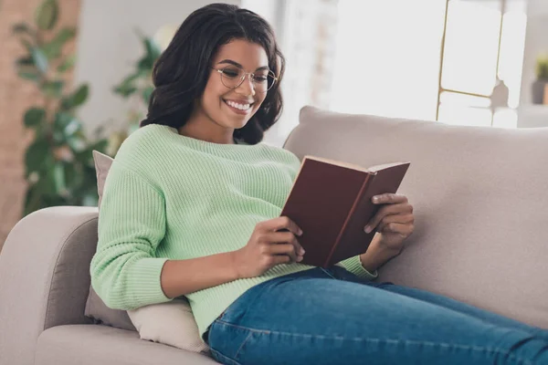 Профиль стороне фото молодой привлекательной женщины счастливый позитивный отдых улыбка расслабиться сидеть на диване читать книгу рассказ роман выходные домой — стоковое фото