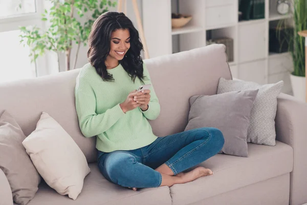 Retrato de atractiva chica alegre centrado sentado en diván utilizando el dispositivo de chat de navegación web en piso apartamento interior — Foto de Stock