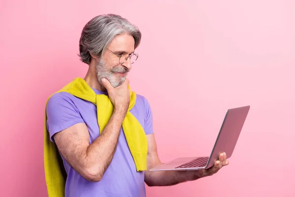 Perfil vista lateral retrato de atraente focado mentalmente hábil homem de cabelos grisalhos usando laptop isolado no fundo cor pastel rosa — Fotografia de Stock