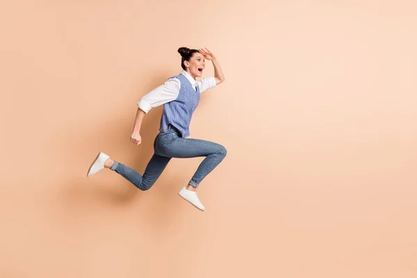 Volledige foto van mooie zoete meisje gekleed gebreide vest springen haasten op zoek ver weg geïsoleerde beige kleur achtergrond — Stockfoto