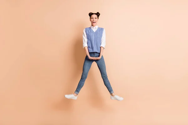 Full length φωτογραφία του γλυκού χαριτωμένο νεαρή κοπέλα φορούν μπλε γιλέκο άλμα ψηλά πόδια πλευρές απομονωμένο μπεζ φόντο χρώμα — Φωτογραφία Αρχείου