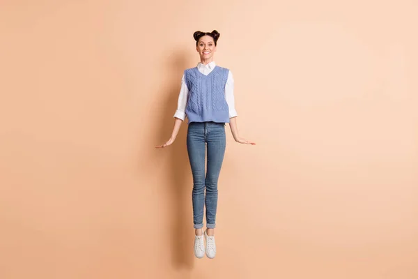 Volledige foto van vrij charmante jonge dame dragen blauwe vest springen hoog geïsoleerde beige kleur achtergrond — Stockfoto