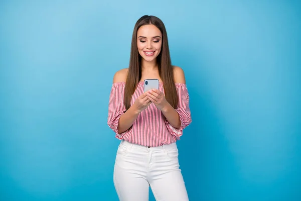 Portrait of cheerful girl use smartphone social network wear red outfit trousers isolated over blue color background — Stock Photo, Image