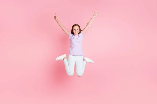 Foto de comprimento total de feliz alegre bonito menina saltar para cima levantar as mãos bom humor isolado no fundo cor-de-rosa — Fotografia de Stock