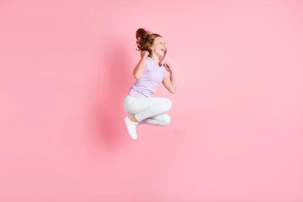 Volledig lichaam profiel zijkant foto van funky vrolijk klein meisje springen omhoog raise vuisten winnen geïsoleerd op roze kleur achtergrond — Stockfoto