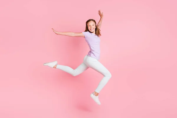 フルボディプロフィールサイド写真の幸せな陽気な小さな女の子ジャンプアップ手孤立したピンク色の背景 — ストック写真