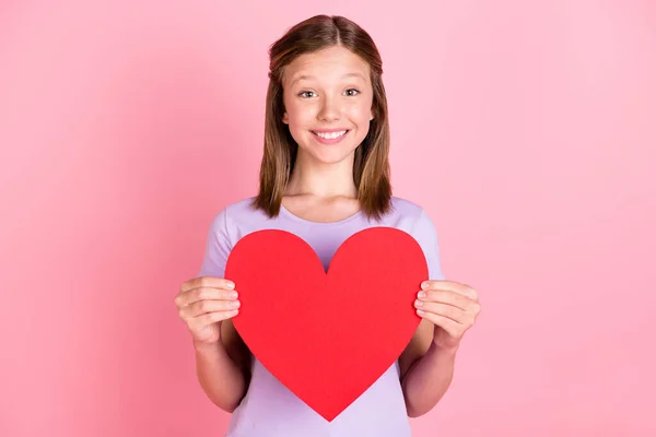 Foto de bonito menina adolescente feliz segurar as mãos forma do coração isolado no fundo cor-de-rosa pastel — Fotografia de Stock