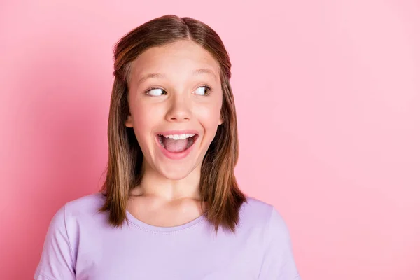 Foto av söta charmiga glada unga tonåring flicka ser tomt utrymme glada nyheter isolerad på rosa färg bakgrund — Stockfoto