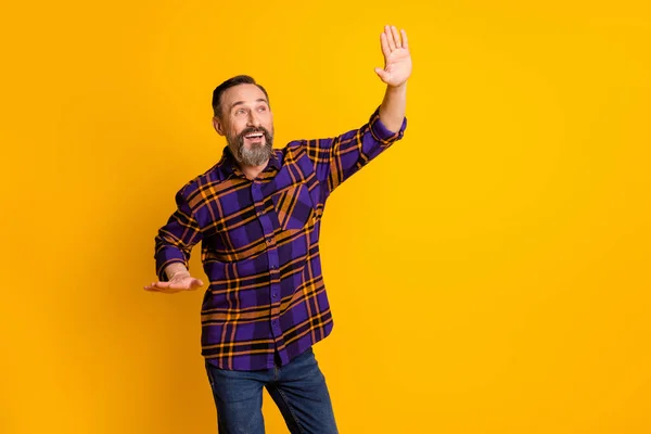 Portrait of attractive funky cheerful guy dancing having fun moving clubbing isolated over bright yellow color background — Stock Photo, Image