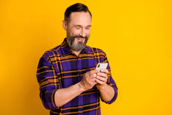 Cep telefonu kullanan mutlu bir adamın fotoğrafı. Gülümseyen internet. Parlak sarı arka planda izole edilmiş. — Stok fotoğraf