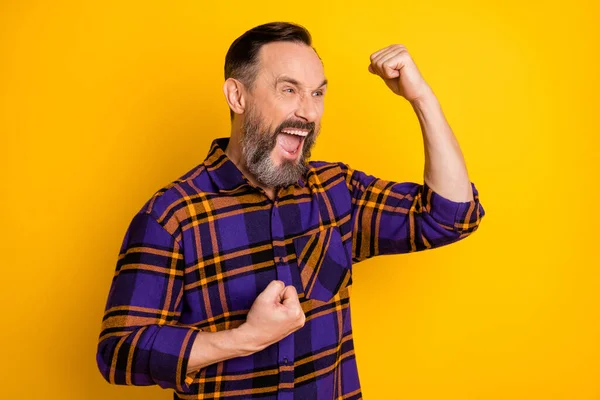 Фото победителя счастливый веселый зрелый мужчина смотреть пустые пространство поднять кулаки победитель ура изолированы на желтом фоне цвета — стоковое фото