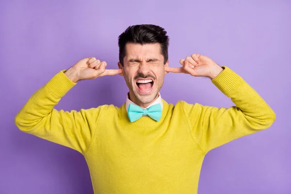 Portret brunet zestresowany facet blisko uszu krzyczeć nosić żółty sweter odizolowany na pastelowym tle koloru liliowego — Zdjęcie stockowe
