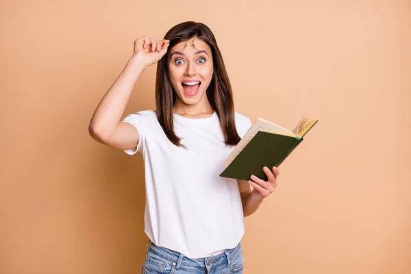 Foto portrét chytré studentky připravuje na zkoušky držení knihy zírá izolované pastelové béžové barvy pozadí — Stock fotografie
