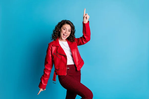 Fénykép az optimista aranyos lány tánc viselni piros kabát nadrág elszigetelt kék színű háttér — Stock Fotó
