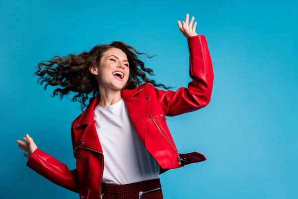 Foto de menina cool otimista dança desgaste casaco vermelho isolado no fundo de cor azul — Fotografia de Stock
