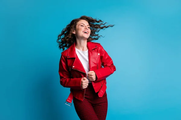 Fénykép az optimista hűvös lány viselni piros kabát nadrág elszigetelt kék színű háttér — Stock Fotó