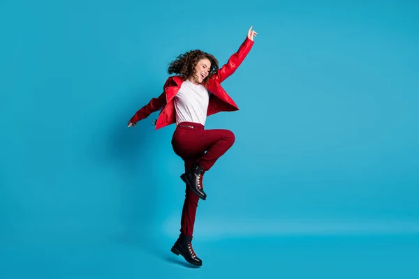 フルサイズプロフィール写真のhooray女の子ジャンプ着用赤ジャケットパンツブーツ孤立した上青色背景 — ストック写真