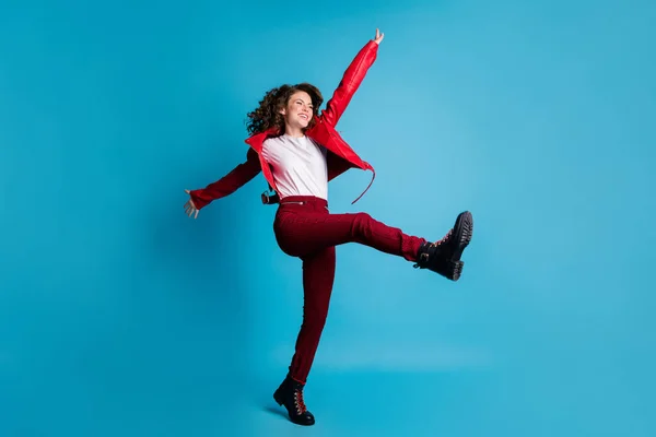 Teljes méretű fotó hurrá lány tánc viselni piros kabát nadrág csizma elszigetelt kék színű háttér — Stock Fotó