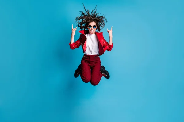 Retrato de tamaño completo de señora despreocupada salto alto muestran lengua símbolo de metal pesado fuera aislado sobre fondo de color azul —  Fotos de Stock