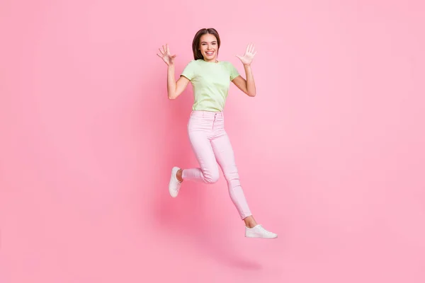 Foto de cuerpo completo de alegre bonita persona salto levantar brazos palmas buen humor aislado sobre fondo de color rosa — Foto de Stock