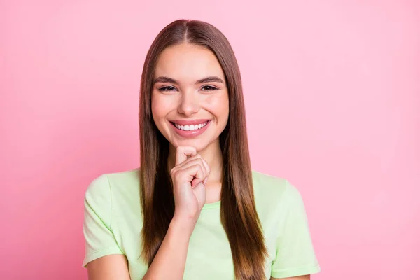 Foto av knepiga drömmande ung dam bära grön t-shirt finger haka leende isolerad pastell rosa färg bakgrund — Stockfoto