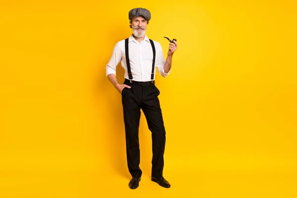 Full length foto di uomo maturo felice sorriso positivo tenere la pipa fumatore tabacco isolato su sfondo di colore giallo — Foto Stock