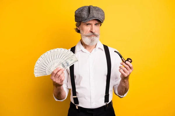 Yaşlı bir adamın resmi. Sigara piposu, tütün parası. Sarı arka planda izole edilmiş nakit para. — Stok fotoğraf