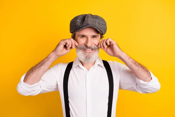 Foto ritratto di uomo barbuto con baffi sorridenti in bretelle camicia bianca isolato colore giallo brillante sfondo — Foto Stock