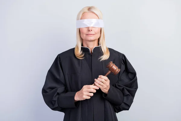 Фото серьезной старухи держать молоток крышку глаза с завязанными глазами носить униформу судьи изолированы на сером фоне цвета — стоковое фото