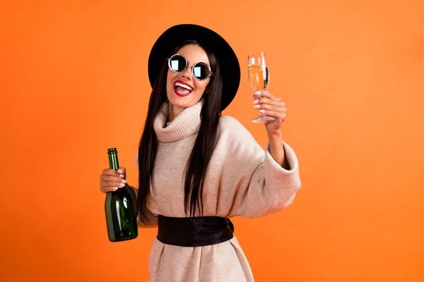Photo de jeune belle charmante fille souriante dans des lunettes de soleil buvant du champagne isolé sur fond de couleur orange — Photo