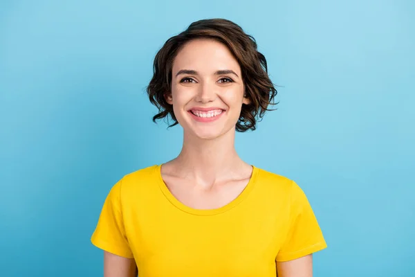 Фото милої веселої дівчини виглядає зубне мерехтливе посмішка носить жовту футболку ізольований синій колір фону — стокове фото