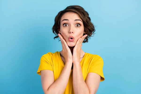 Fénykép izgatott őrült fiatal lány kezek arc néz kamera viselni sárga póló elszigetelt kék szín háttér — Stock Fotó
