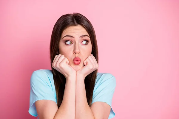 Photo of terrified lady arms on chin look side empty space wear casual blue t-shirt isolated pink pastel color background