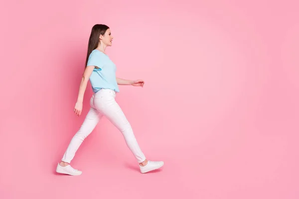Full kroppsprofil sida foto av trevlig flicka promenad copyspace isolerad över rosa färg bakgrund — Stockfoto